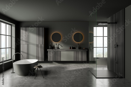 Dark bathroom interior with bathtub and two sinks  shower and window