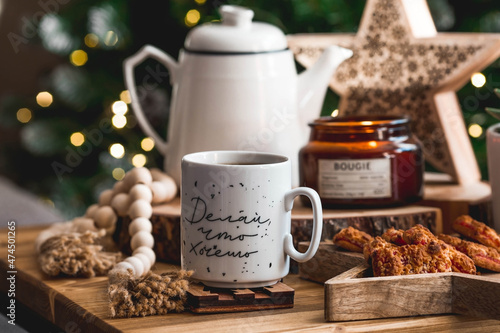 Lifestyle. A cup of tea on a wooden table during the Christmas holidays. The inscription on the mug in Russian: do what you want. Still-life. The concept of home warmth, comfort.