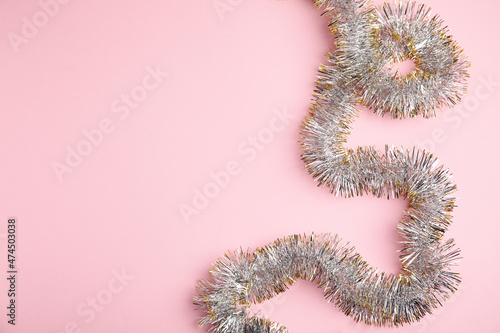 Sparkling tinsel on pink background  top view. Space for text