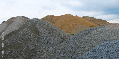 Tableau sur toile Piles of gravel and yellow sand used for the construction forming shapes of moun