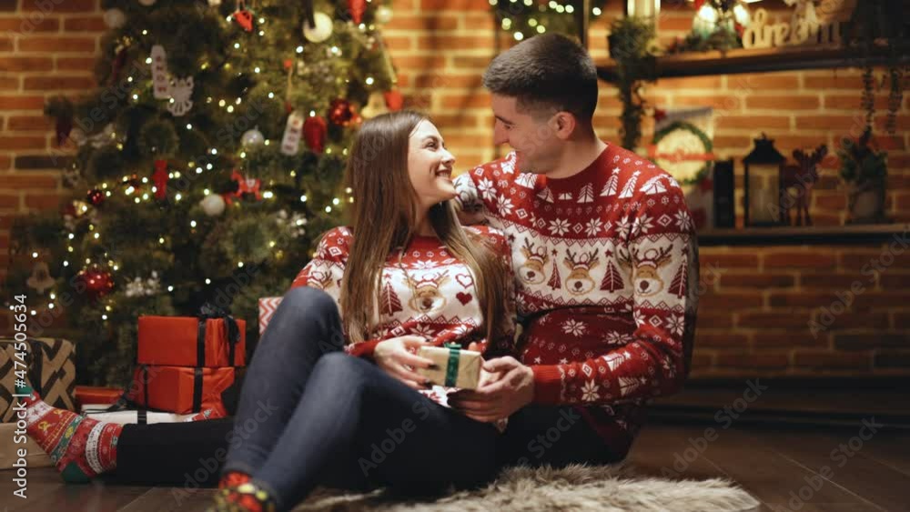 Young boyfriend making holiday surprise to his woman celebrating together giving birthday christmas present gift box. Shopping online gifts for Christmas. Love couple. Romantic date Young boyfriend making holiday surprise to his woman celebrating together giving birthday christmas present gift box. Shopping online gifts for Christmas. Love couple. Romantic date