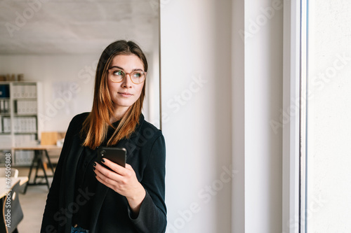 Photos Pensive thoughtful office worker standing staring out of window