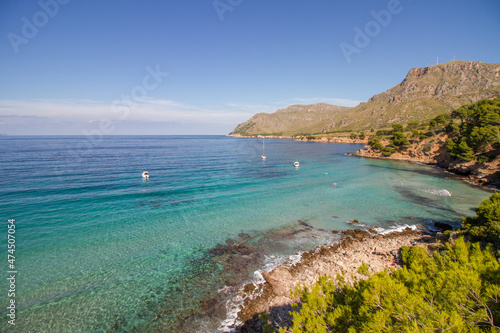 Turquoise water, rocky coast line and boats at beautiful beach Cala na clara near Betlém at Mallorca island, Mediterranean Sea, Spain photo
