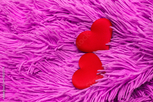 two red textile hearts on a plush juicy acid pink plaid  for the design of valentines and wedding invitations