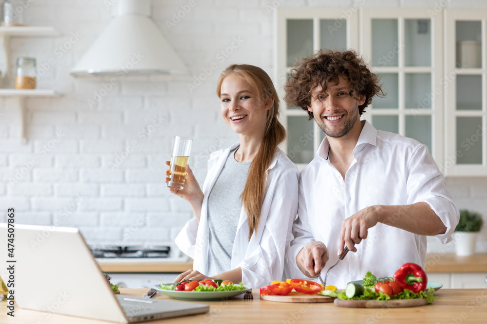Young couple using the internet to look up recipe. Cooking together salad, having fun in the kitchen. Young couple using the internet to look up recipe. Cooking together salad, having fun in the kitchen.
