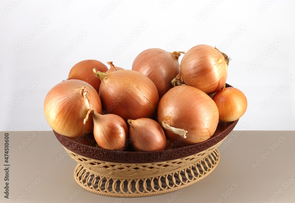 onions (Latin Allium cepa) lie in a wicker plastic container onions (Latin Allium cepa) lie in a wicker plastic container