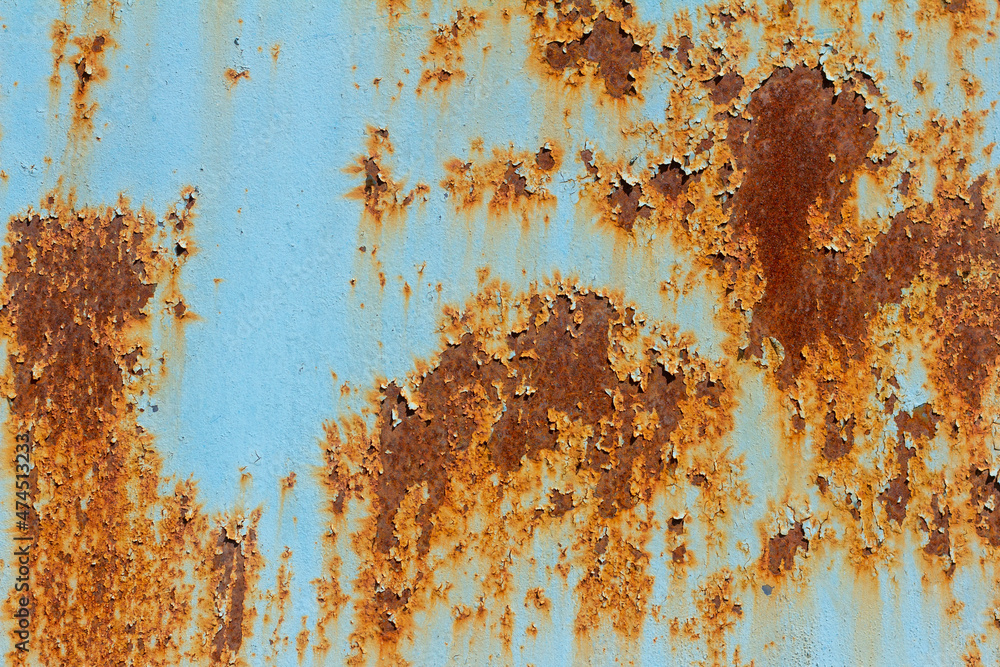 A rusty blue metal wall with fallen paint, a rusty background. A rusty blue metal wall with fallen paint, a rusty background.