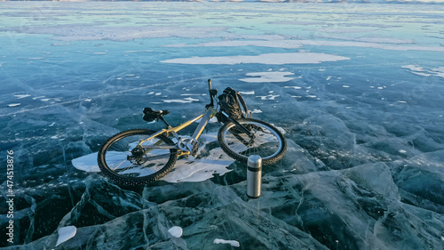Man and his bicycle on ice. He looks at the beautiful ice in the