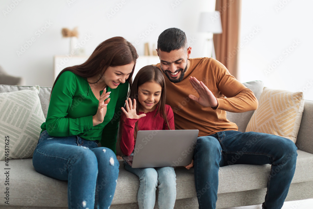 Arab family making video call using laptop waving hands Arab family making video call using laptop waving hands