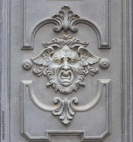 screaming human face with wings, mythological figure carved on palace door
