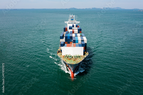 aerial view head container ship full speed floating in green sea, business and industry Transportation cargo logistics services of international by container ship in ocean