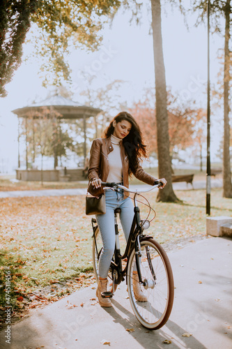 Fototapeta Naklejka Na Ścianę i Meble -  Young woman riding bicycle on autumn day