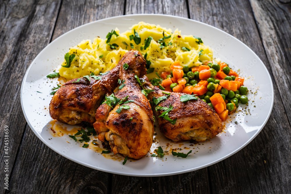 Barbecue chicken drumsticks with potato puree, grean peas and carrot on wooden table
Barbecue chicken drumsticks with potato puree, grean peas and carrot on wooden table
