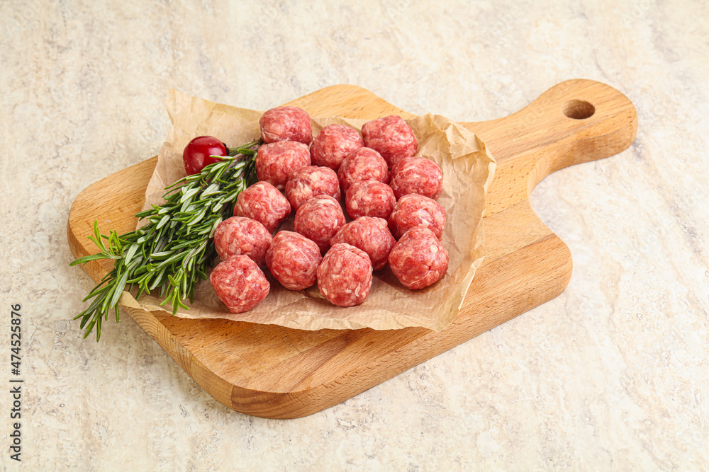 Raw uncooked beef meatballs served rosemary Raw uncooked beef meatballs served rosemary