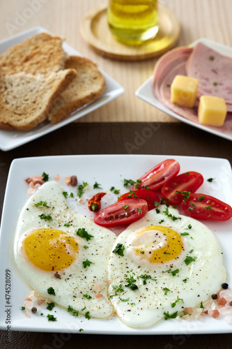 Fried eggs with cherry tomatoes, cheese and salami