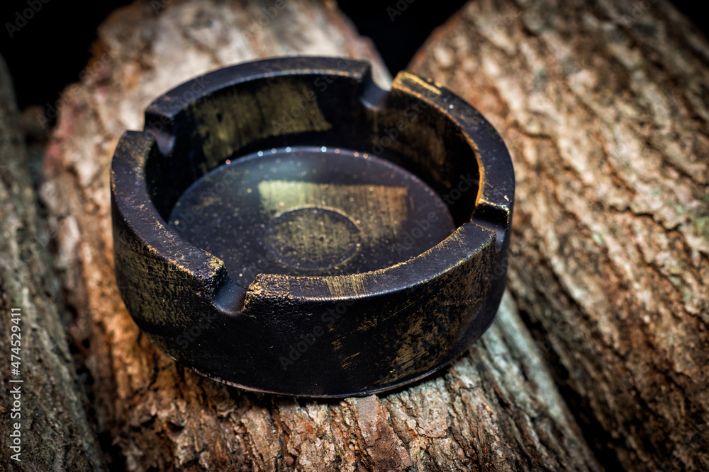 antique-looking round ashtray standing on wood antique-looking round ashtray standing on wood