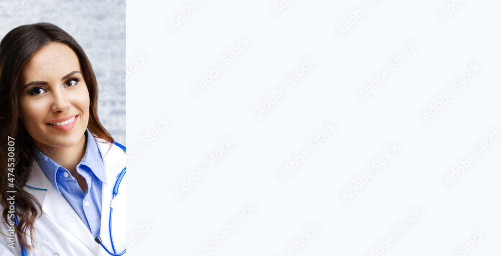 Portrait image of happy smiling female doctor with mockup blank signboard with copy space, at office. Young brunette woman in medical, clinic, healthcare concept. Portrait image of happy smiling female doctor with mockup blank signboard with copy space, at office. Young brunette woman in medical, clinic, healthcare concept.