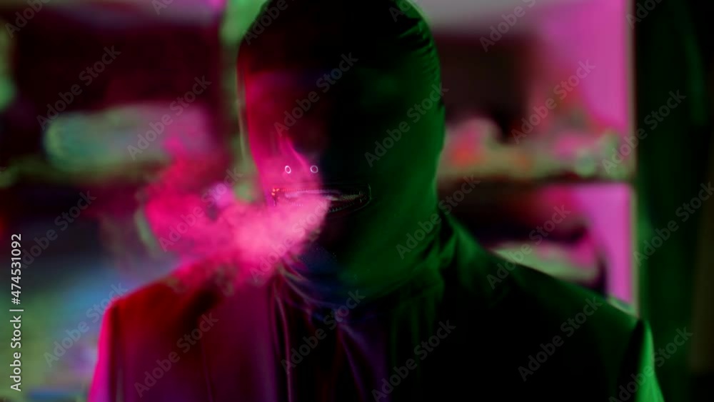 psychedelic view on man with black mask on head exhaling smoke, horror concept psychedelic view on man with black mask on head exhaling smoke, horror concept