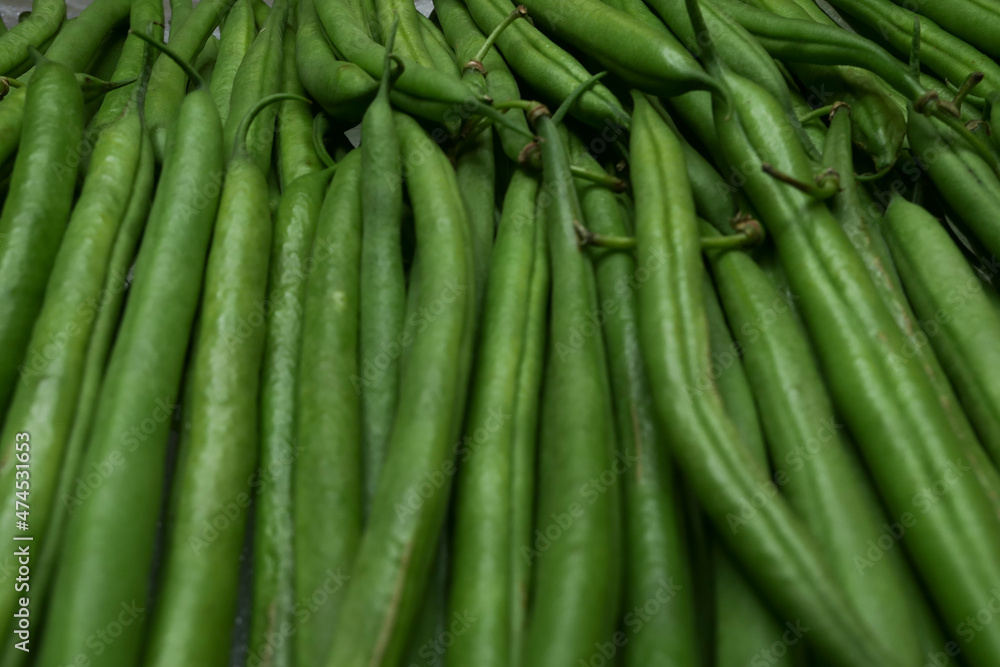 Close-up of fresh green beans lined up. Immature pods of common beans. Vegetable for vegetarian. Food for vegan. Close-up of fresh green beans lined up. Immature pods of common beans. Vegetable for vegetarian. Food for vegan.