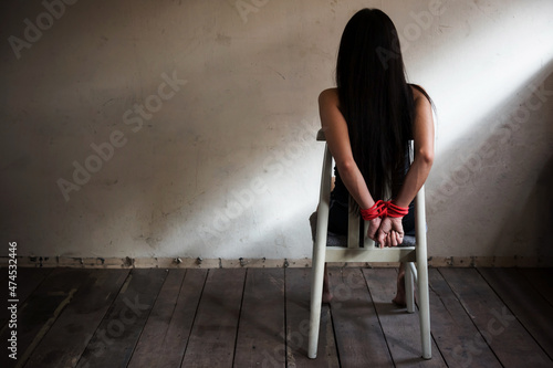 Fotografia Hostage woman tied on chair in abandon house