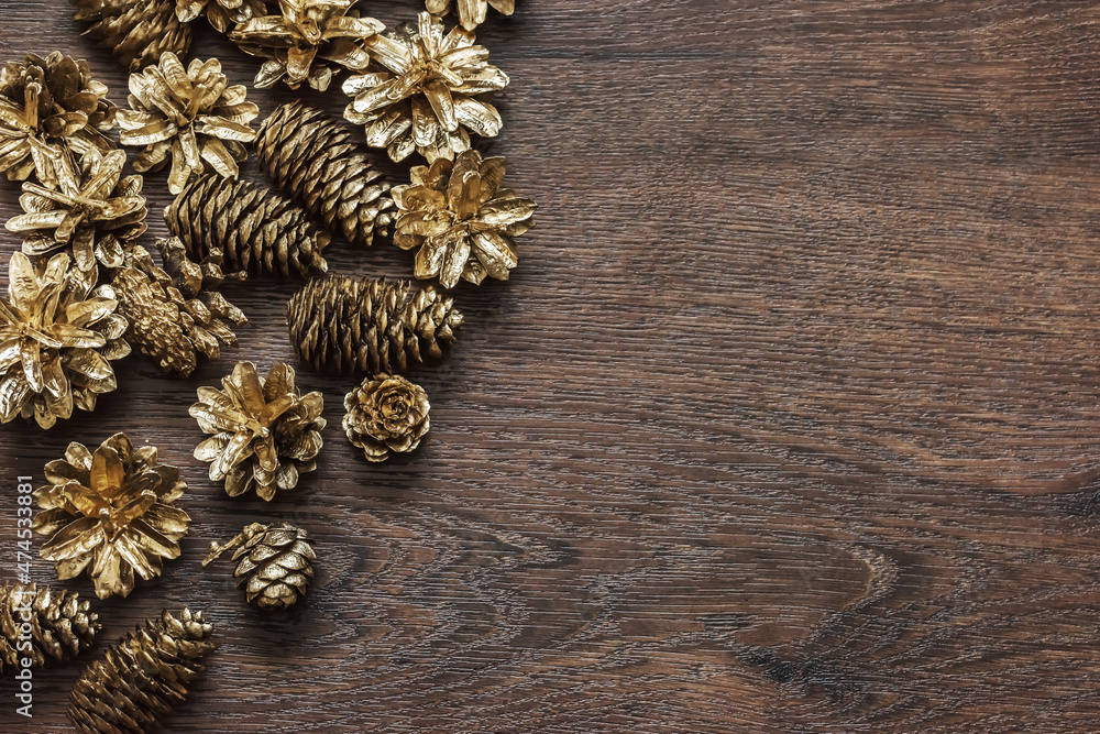 Conifer cones painted in gold on wooden surface Conifer cones painted in gold on wooden surface