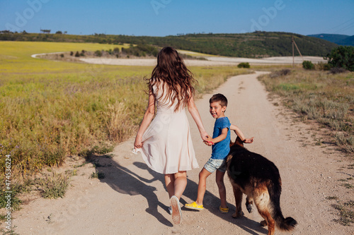 mother and son walking with the dog in nature