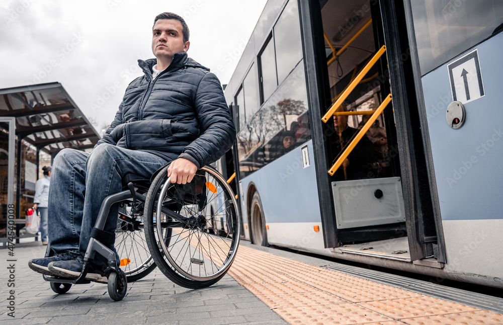 Person with a physical disability exits public transport with an accessible ramp. Person with a physical disability exits public transport with an accessible ramp.