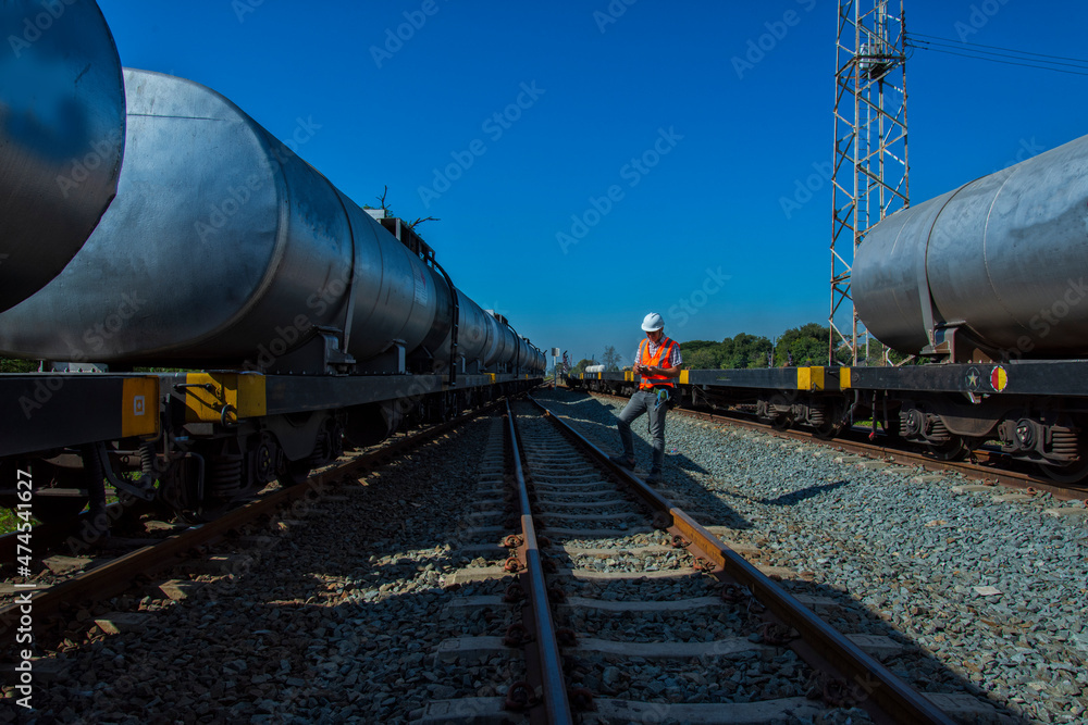 train in the countryside. engineer checking tank for transportation on rail system. Engineer under inspection and checking rail and oil tank. train in the countryside. engineer checking tank for transportation on rail system. Engineer under inspection and checking rail and oil tank.