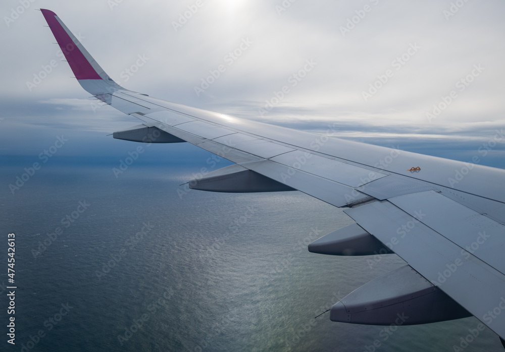 Fototapeta premium Aerial evening sky and clouds view above ocean from airplane porthole.