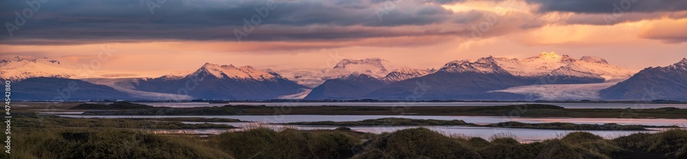 Sunrise Stokksnes cape sea beach, Iceland. Amazing nature scenery, popular travel destination. Autumn grass on black volcanic sand dunes.