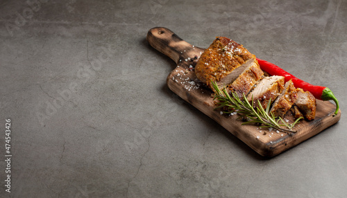 Roast pork meat with herbs and spices on wooden cutting board. Long banner format