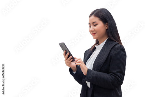 A beautiful Southeast Asian Thai woman in a formal suit is smiling while looking at her mobile phone or smartphone. Isolate on white background, business woman concept.