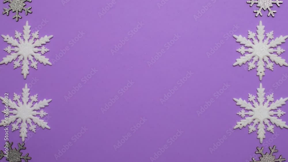 Christmas white and silver snowflakes moving on purple theme.Stop motion Christmas white and silver snowflakes moving on purple theme.Stop motion