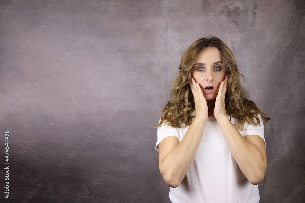 shocked young woman on a gray background. Copy space for text