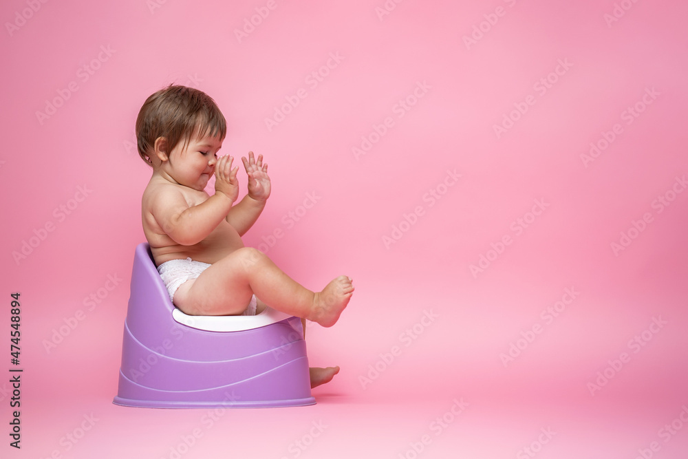 Cute baby in a diaper sitting on a potty. Toilet and potty training. Cute baby in a diaper sitting on a potty. Toilet and potty training.