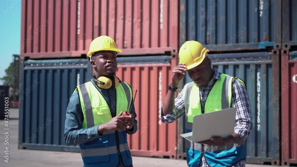 Worker team checking containers box from cargo, Dock workers discuss shipping logistics in a shipyard Worker team checking containers box from cargo, Dock workers discuss shipping logistics in a shipyard