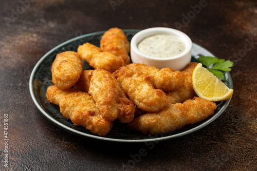 Crispy Fish strips with tartar sauce in a plate