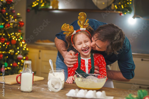 Merry Christmas. My daughter helps my dad cook. Family cooking of festive food. father and daughter are making Christmas cookies. happy holidays. Evening time, happy family in the kitchen. photo