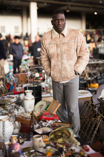 Fototapeta Naklejka Na Ścianę i Meble -  ordinary african american guy sells things at a flea market