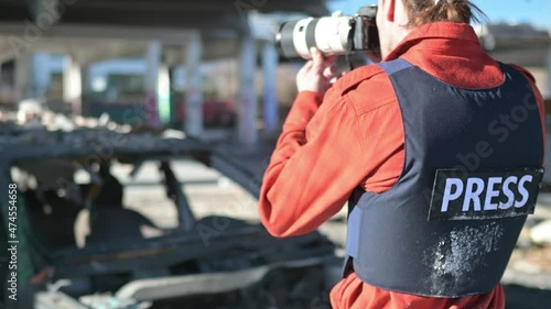 One man, war journalist with digital camera at the place of action, in war zone.