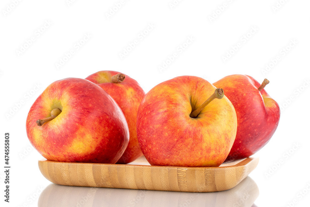 Four juicy red apples on a bamboo plate, close-up, isolated on white. Four juicy red apples on a bamboo plate, close-up, isolated on white.