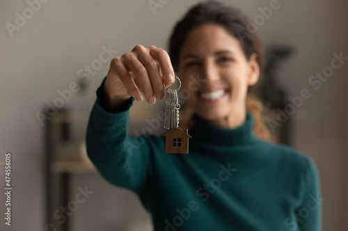 Crop close up portrait of happy millennial Latino woman show keys to new house or apartment. Smiling young Hispanic female renter or tenant celebrate relocation moving to own home. Rent concept.