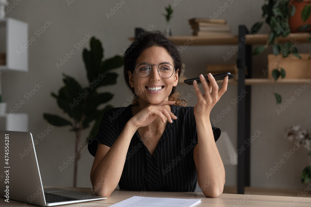 Smiling young Latino woman sit at table at home office record audio ...