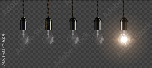 Light bulbs hang from ceiling with one bright lightbulb glowing, symbol of innovation