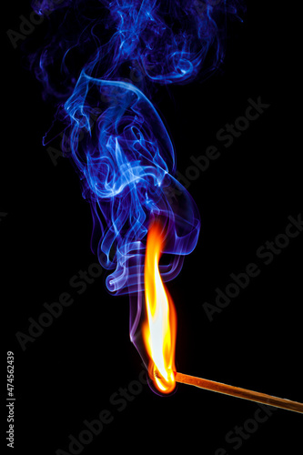 flame and smoke of a matchstick on black background