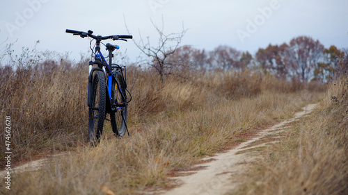 bike stands on in the field. A mountain bike stands on a field path with dry autumn grass. cycling. Mountain bike. outdoor cycling activities. active rest, sports, travel. space for text