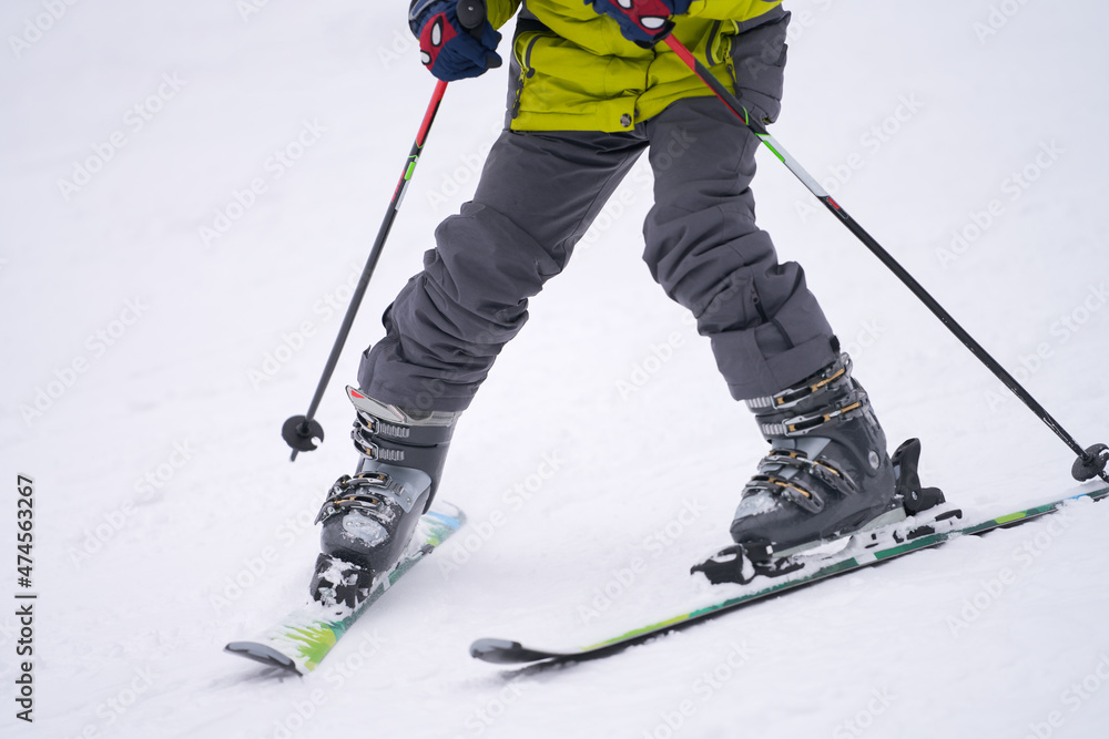 The legs of a teenager skiing in boots with four clips. Close-up. The legs of a teenager skiing in boots with four clips. Close-up.