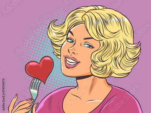 Beautiful woman eats a red heart valentine, love in a restaurant