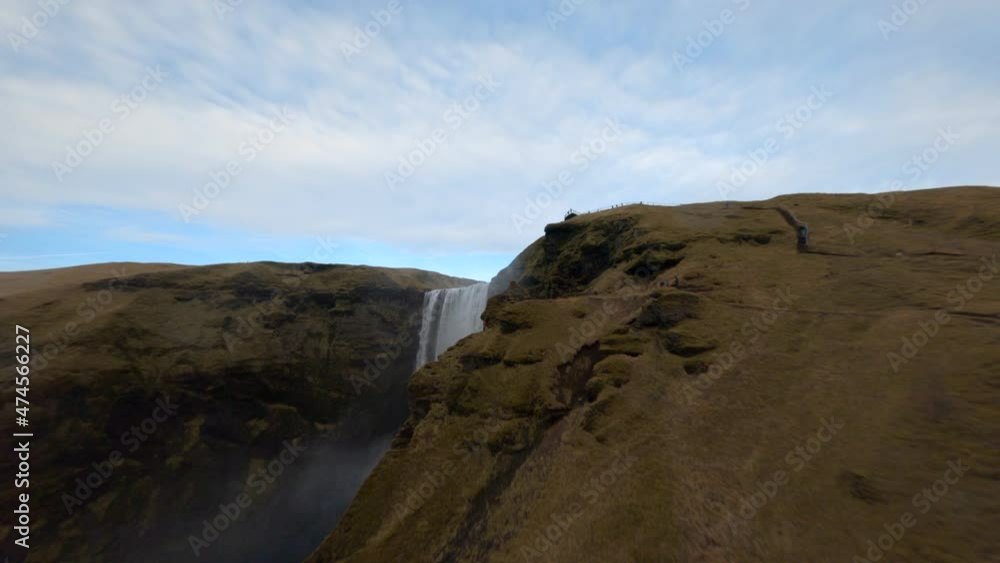 Aerial drone fpv view of man standing near Skogafoss waterfall in Iceland. Aerial drone fpv view of man standing near Skogafoss waterfall in Iceland.