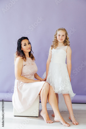 portrait of beautiful mother and daughter in dresses